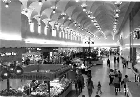 Concourse with Strouss, Wild Pair, Regal Shoes, Woolworths, and Frontier Fruit & Nut.