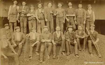 workers with tongs to grab shhet metal