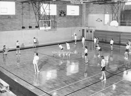Girls play softball in new gym.