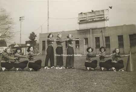 Cheerleaders posing in front of Riverside Stadium, ca 1948. The football stadium was built as a US Government WPA project in 1934. The concrete stands had wooden bleacher seats and locker rooms.