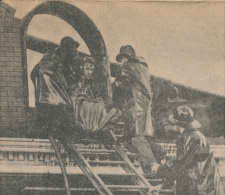 Firemen lower the body of Mrs. Alex Aulin.