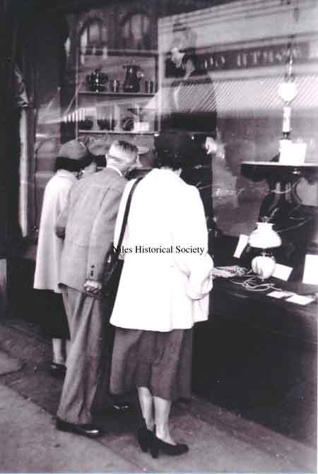 Homer Hoffman looking at antiques in display window.