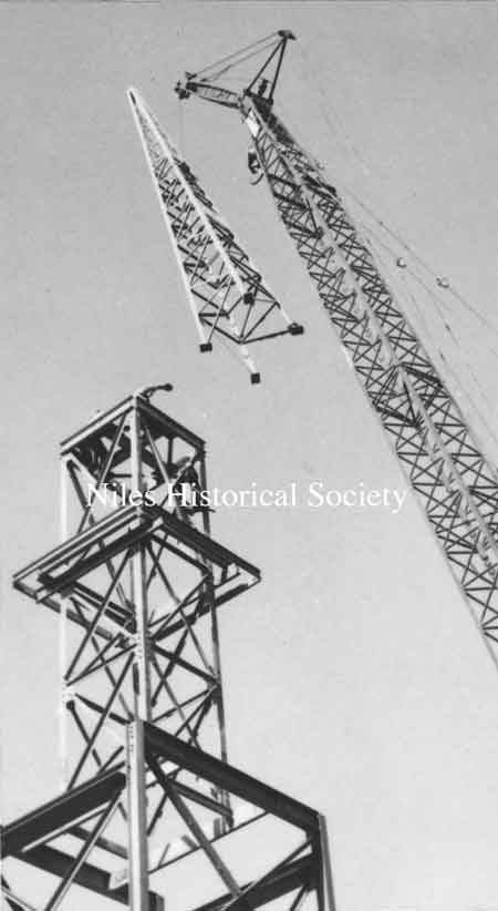 Top of steeple being hoisted to its final position.