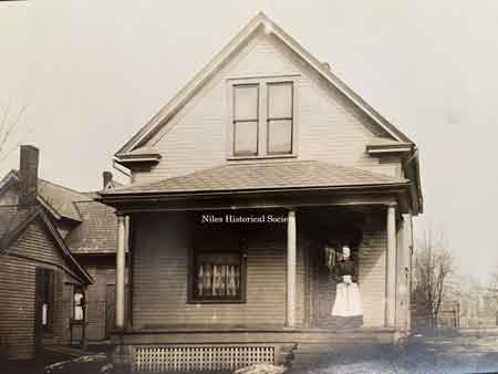 Grandmother Burnside standing on front porch on Linden Avenue.