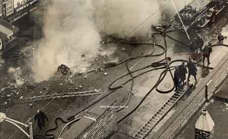 the fireman(Arnold Danes) in the bottom quadrant of the photo. He appears to have been blown off a ladder – perhaps by a falling brick wall.