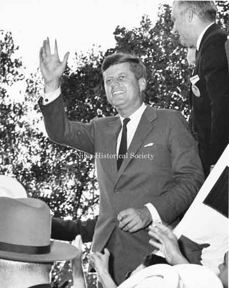 JFK waves to bystanders as