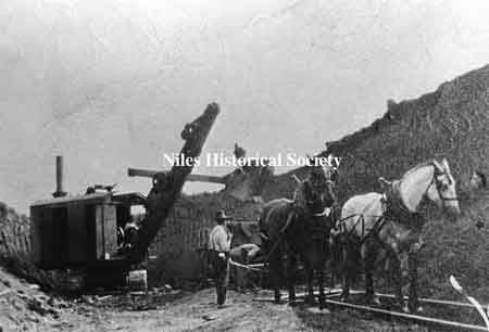 Horse drawn wagon and steam shovel excavating the underpass.