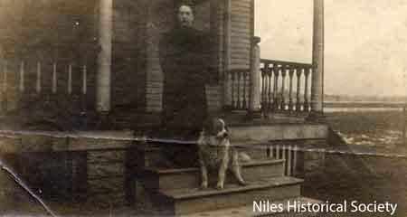 A photograph of Edith Ohl Partridge, standing on the front porch of the