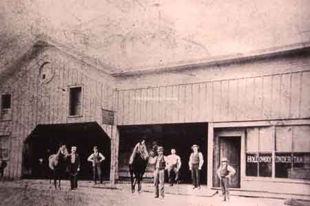 Holloway's Livery and Undertaking was located on East Park Avenue. James C. Holloway(hands on hips) and Ray Holloway-by door, ca 1893.