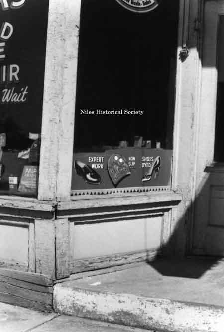 Photo taken of detail storefront of Cook’s Rapid Shoe Repair, located on East State Street.
