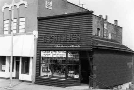 Photo taken of Schink's Marine and T.V. located at 33 East State Street (east side) in down town Niles before urban renewal.